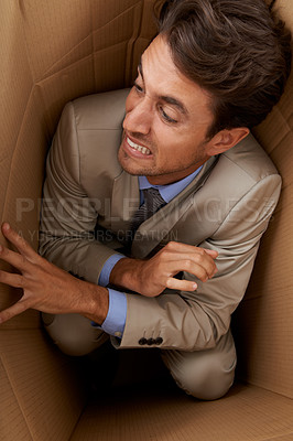 Buy stock photo Businessman, trapped and box at work with stress, scared and fear in office for career or startup. Entrepreneur, corporate and person isolated in cardboard at workplace with frustrated and anxiety