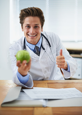 Buy stock photo Thumbs up, apple and portrait of man doctor with stethoscope for positive, good and confident attitude. Happy, smile and young healthcare worker with fruit in medical office of hospital or clinic.