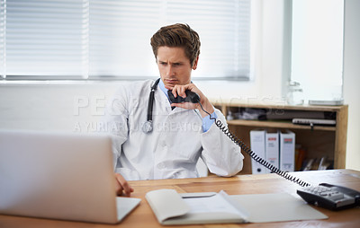Buy stock photo Laptop, phone call and man doctor in his office for telehealth consultation at hospital. Confused, professional and young male healthcare worker on mobile discussion with landline in medical clinic