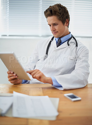 Buy stock photo Tablet, research and doctor reading in his office for diagnosis or treatment at medical hospital. Internet, digital technology and professional young male healthcare worker sitting by desk in clinic.