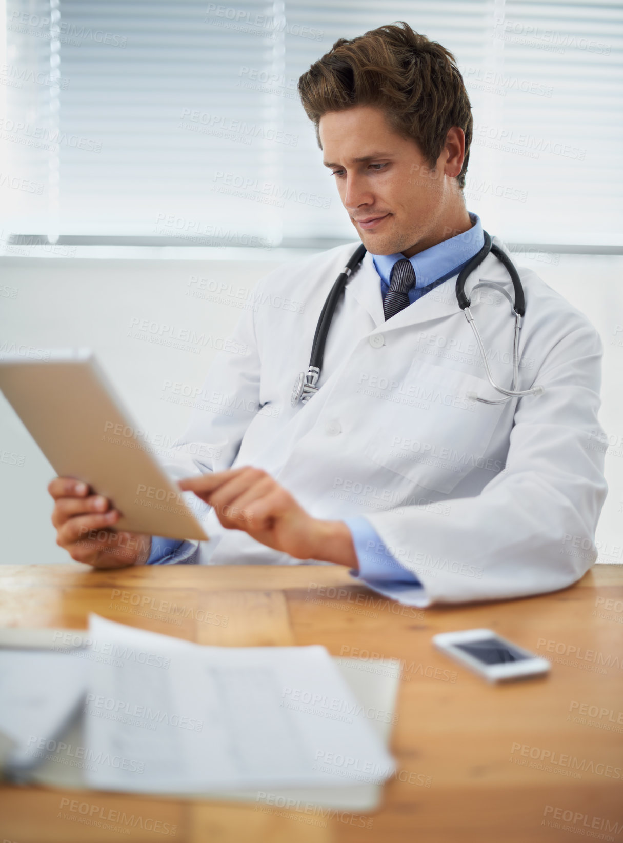 Buy stock photo Tablet, research and doctor reading in his office for diagnosis or treatment at medical hospital. Internet, digital technology and professional young male healthcare worker sitting by desk in clinic.