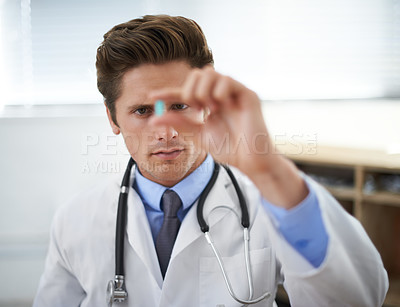 Buy stock photo Curious man, doctor and checking pill for healthcare, cure or drugs at hospital or office. Male person, surgeon or medical nurse looking at medication in research, study or examination at clinic