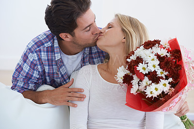 Buy stock photo Man, flowers and kissing in home, happy woman and touch boyfriend for anniversary celebration. Birthday gift, romance and bouquet for love, present and valentines day with romantic gesture and smile
