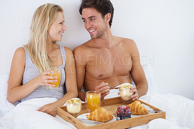Buy stock photo Happy couple, food and breakfast in bed for morning, wakeup or early meal together in relax at home. Man and woman smile enjoying healthy snack, vitamin c juice or diet for love in bedroom at house
