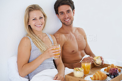 Buy stock photo Portrait of happy couple, food and breakfast in bed for morning, wake up or meal together to relax. Man, smile or woman in home eating healthy snack or drinking juice for diet for love in bedroom