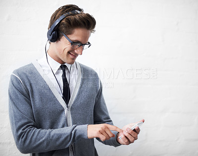 Buy stock photo Man, headphones and listening to audio and phone for music by wall background, sound and peace. Male person, smartphone and streaming radio or podcast, online and hearing song and mobile application