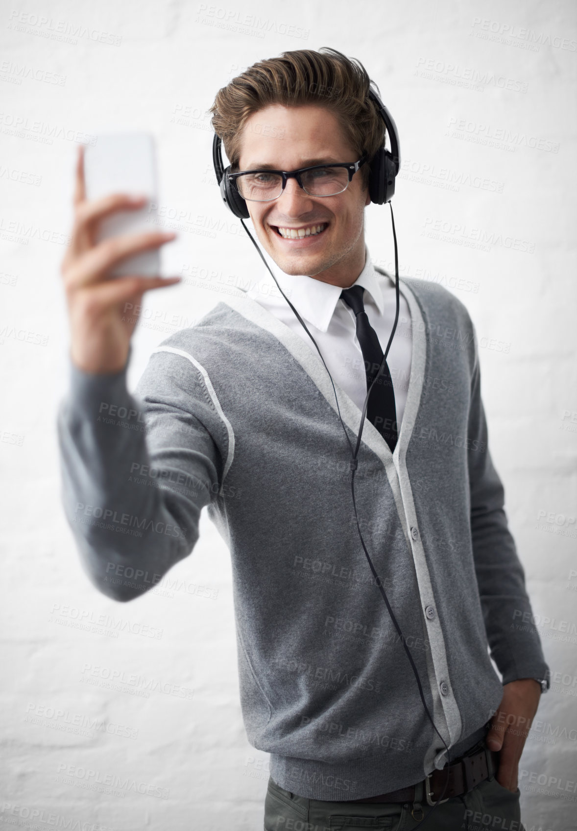 Buy stock photo Business man, headphones and selfie with texting, reading and listening to music by wall background. Influencer, person or employee with photography, audio streaming subscription and social network