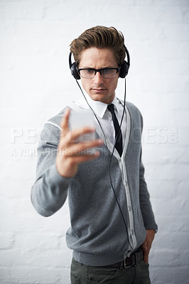 Buy stock photo Business man, headphones and phone with texting, reading and listening to music by wall background. Entrepreneur, person or employee with smartphone, audio streaming subscription and social network