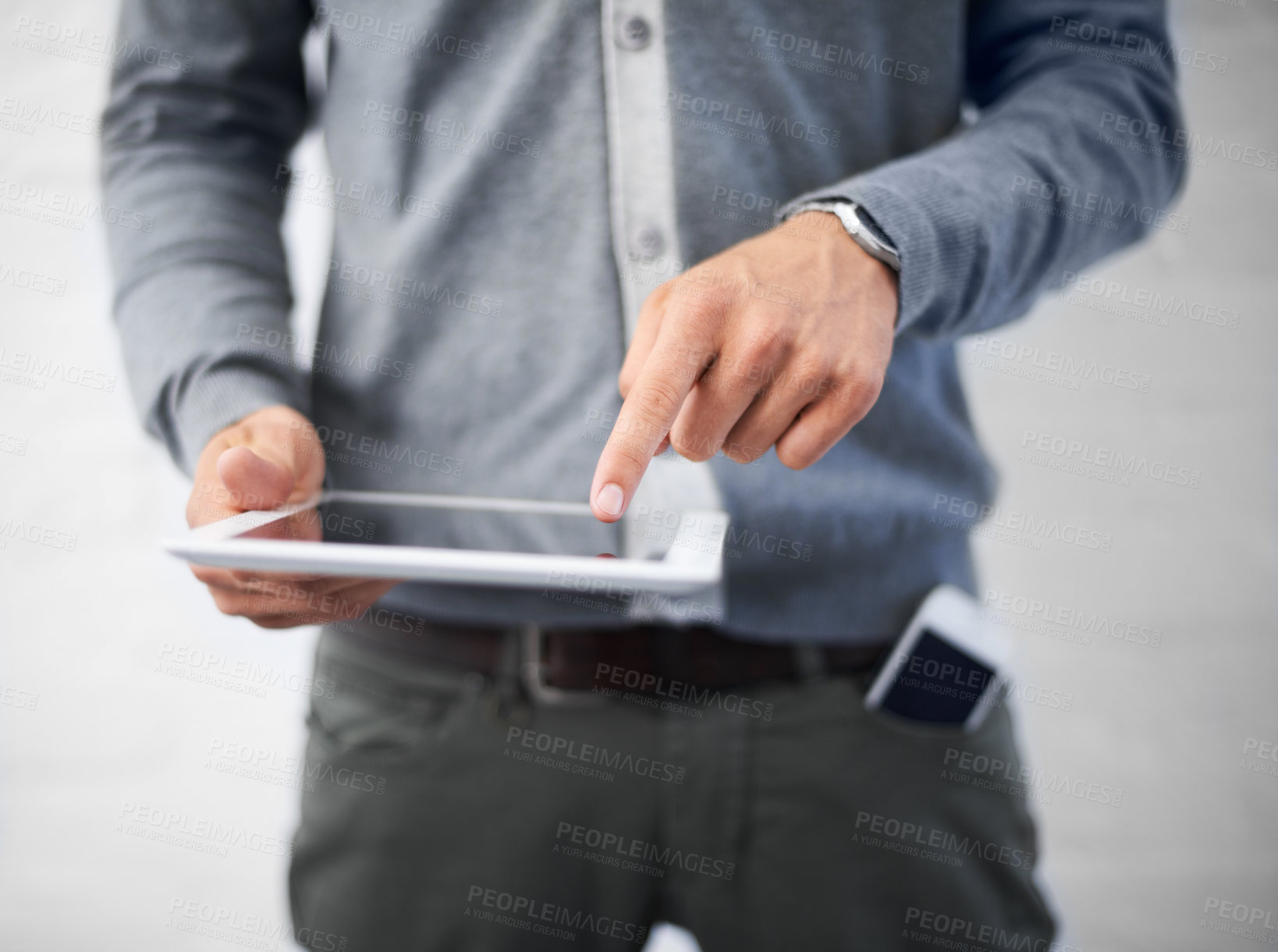 Buy stock photo Cropped image of a young man working on his digital tablet