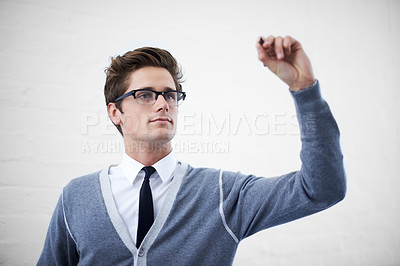 Buy stock photo A handsome young nerdy guy writing something in copyspace