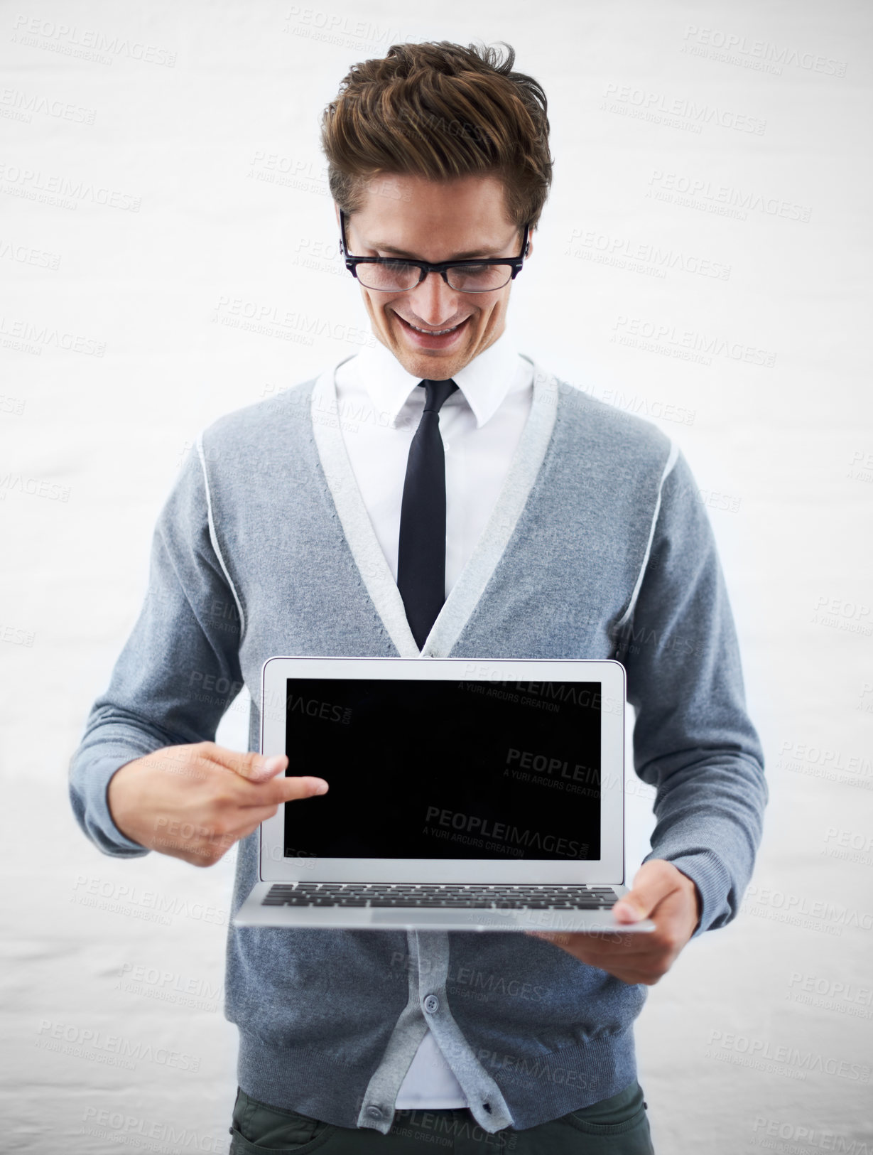 Buy stock photo A young nerdy guy pointing at copyspace on his laptop screen