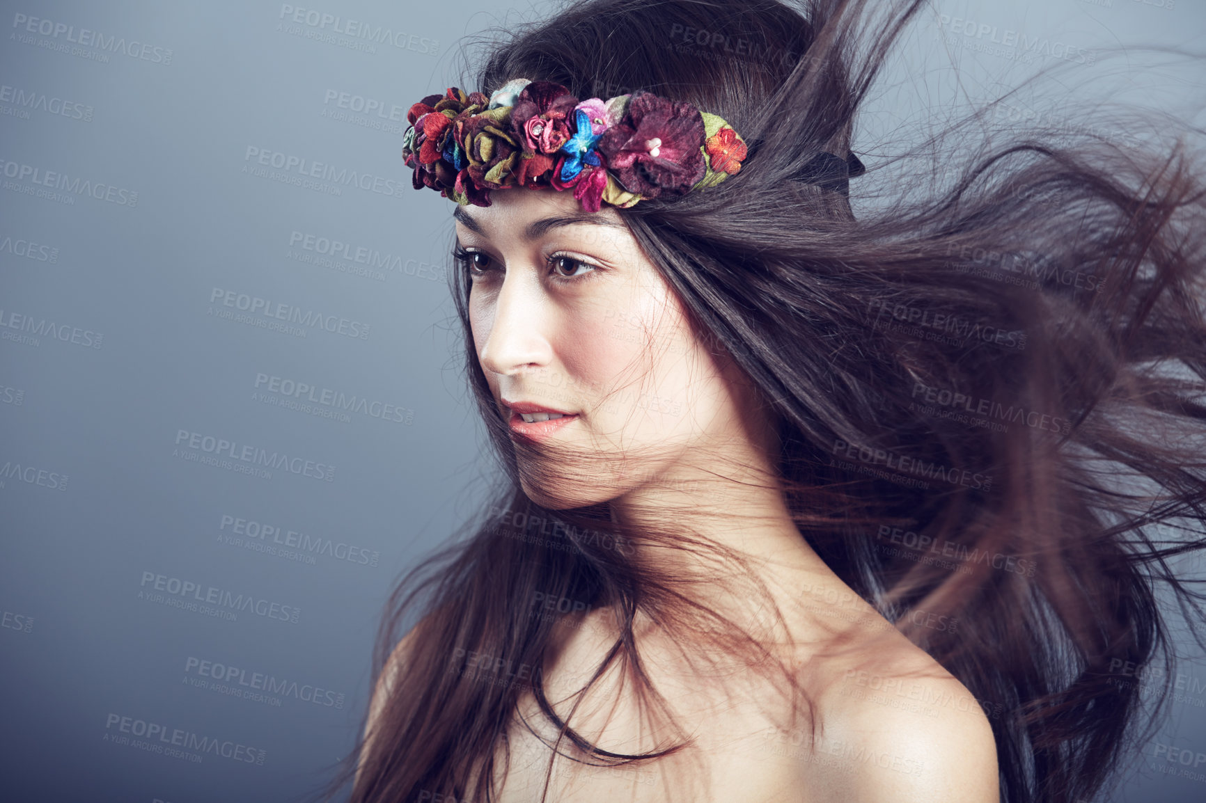 Buy stock photo Woman, flower crown and wind in hair for beauty, skin glow and wellness on grey background. Keratin treatment, hairstyle with floral headband or accessory, dermatology and cosmetics in studio