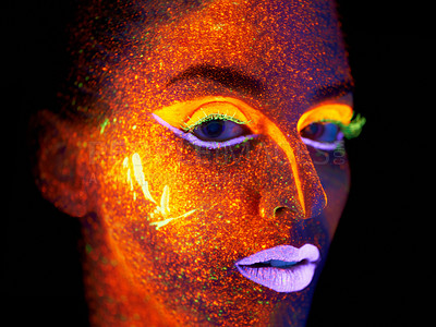 Buy stock photo Portrait of a young woman with with neon paint on her face posing
