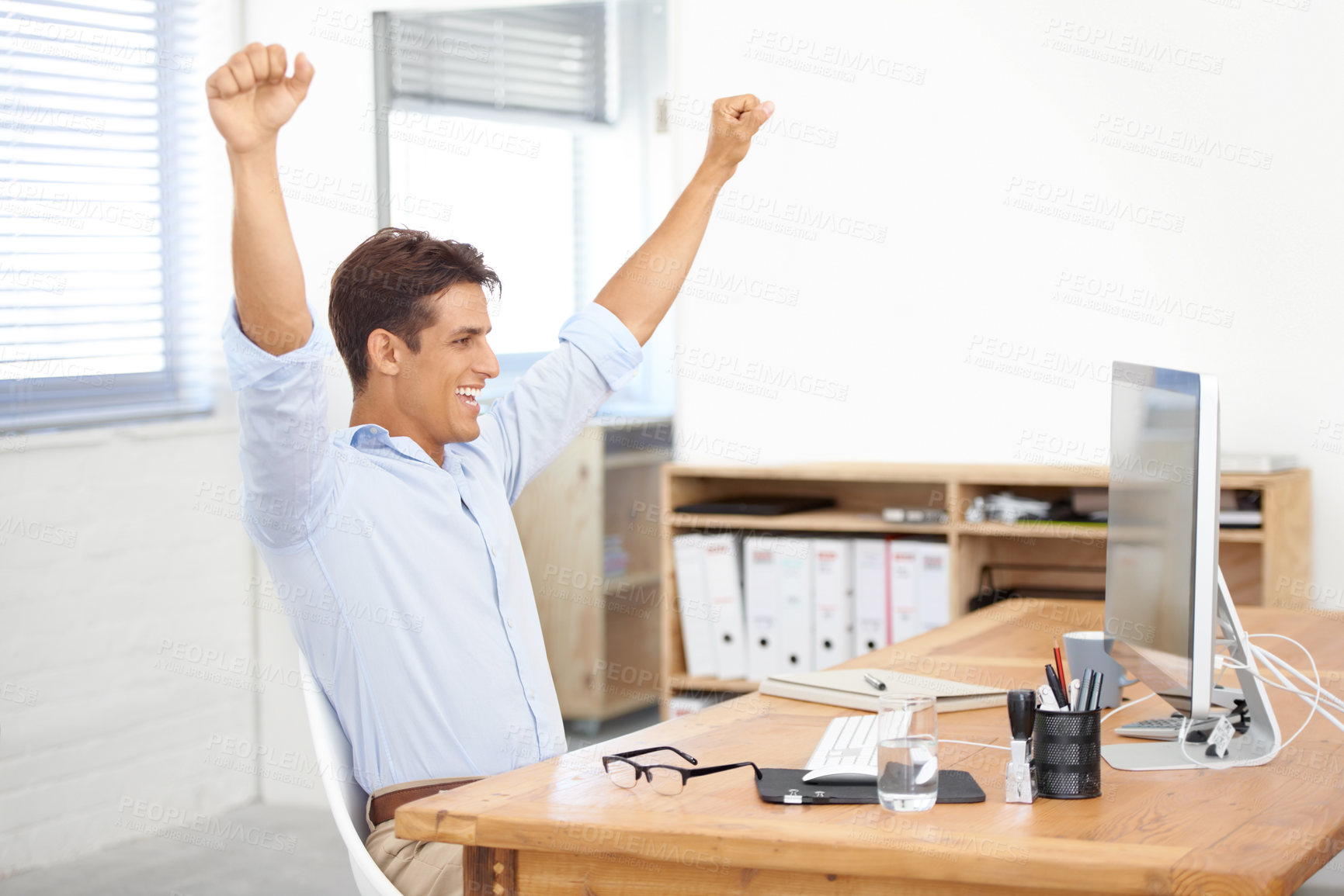 Buy stock photo Happy businessman, fist pump and celebration for winning, success or bonus promotion at office. Excited man or employee smile by desk or table for prize, deal or good news on computer at workplace