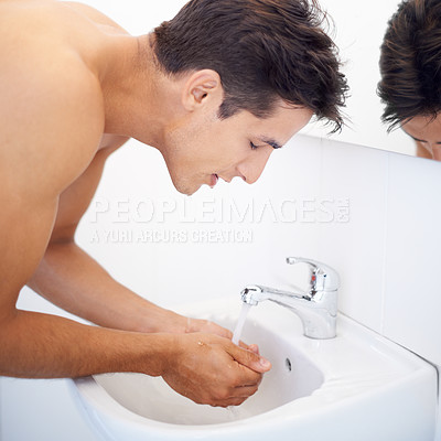 Buy stock photo Man, washing face and water for hygiene in mirror, clean and cosmetics or skincare. Male person, bathroom and wellness in morning routine, reflection and grooming or self care and basin at home