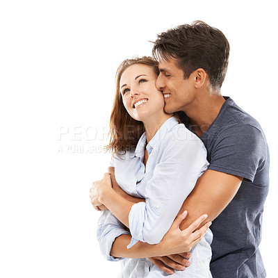Buy stock photo A happy young couple embracing happily against a white background