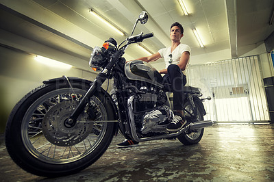 Buy stock photo A handsome young man sitting on his motorcycle