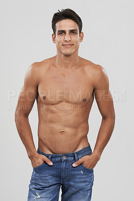 Buy stock photo Man, portrait and confident in studio for fashion, smiling and bodybuilder in jeans for style. Male person, shirtless and fitness or muscle progress, face and body care or wellness by gray background