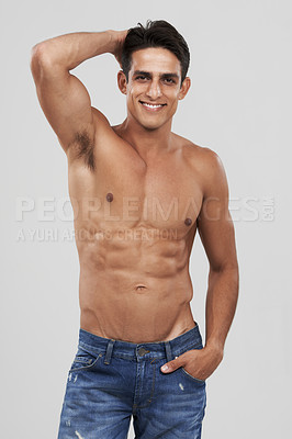 Buy stock photo Man, portrait and smile in studio for fashion, confidence and bodybuilder in jeans for style. Male person, shirtless and fitness or muscle progress, face and body care or wellness by gray background
