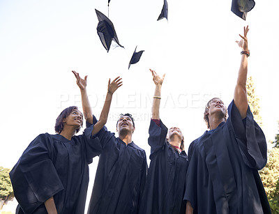 Buy stock photo A group of university graduates throwing their hats in celebration