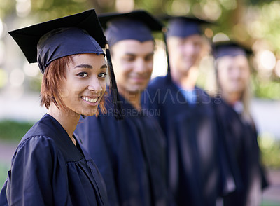 Buy stock photo A group of smiling graduates standing in a row and looking at the camera