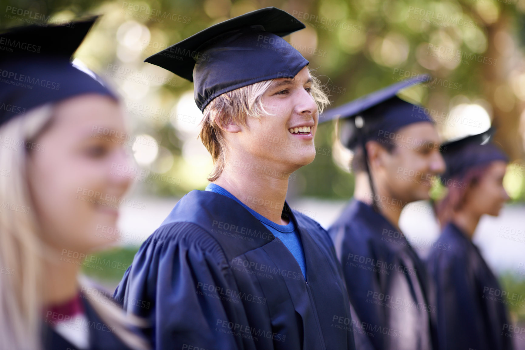 Buy stock photo Man, graduate and university achievement for education with ceremony outdoor. Students, smile and graduation event for academic success, higher learning and certification with pride and profile