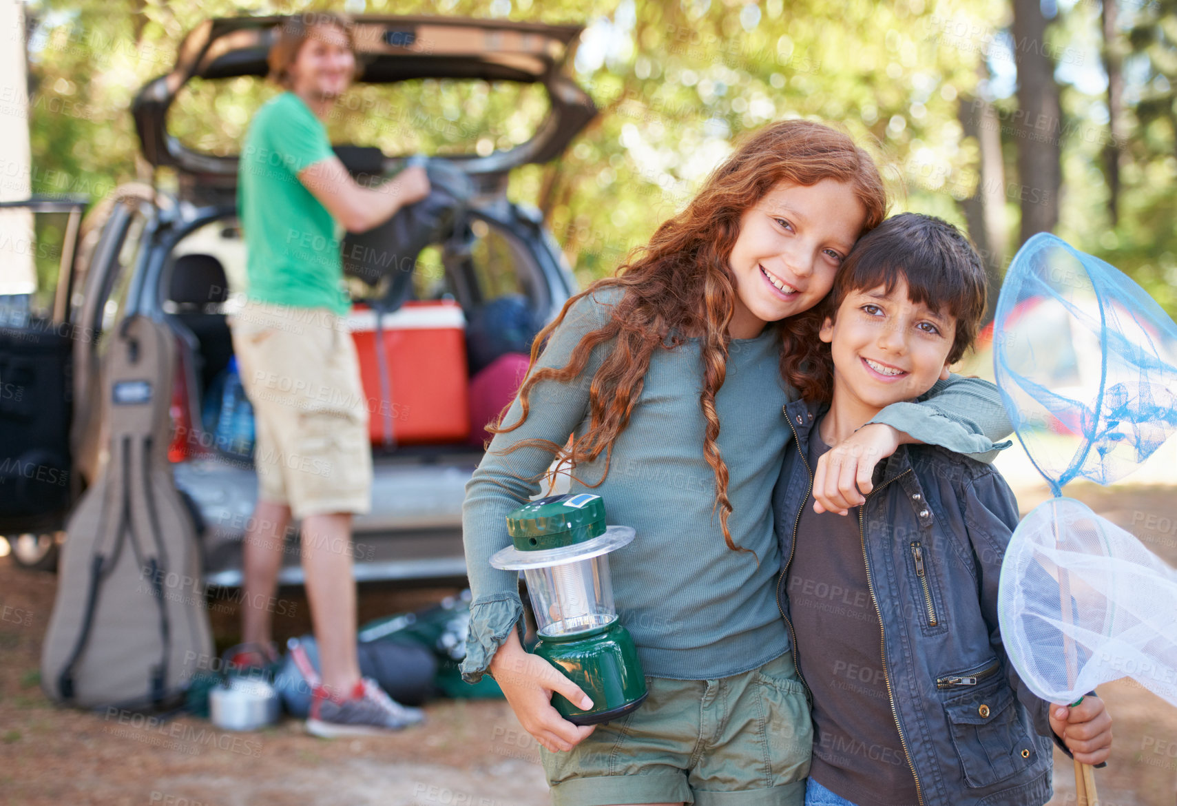 Buy stock photo Happy siblings, portrait and hug for camping holiday, road trip or family vacation together in nature. Sister hugging brother with smile and lantern for camp adventure, travel or getaway in forest