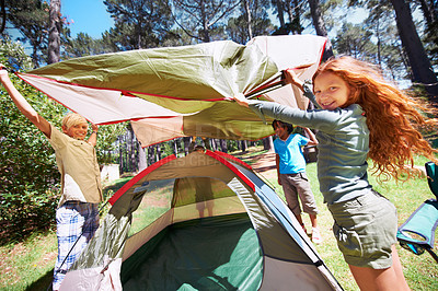 Buy stock photo Happy children, portrait and tent setup in camping forest for shelter, cover or insurance together on the grass in nature. Kids in teamwork setting up tents for camp adventure or holiday in the woods