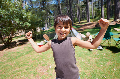 Buy stock photo Boy child, flexing outdoor in portrait and fun at summer camp, happiness and celebration with smile. Kid in nature, adventure with winner or champion, playful youth camper in forest and freedom