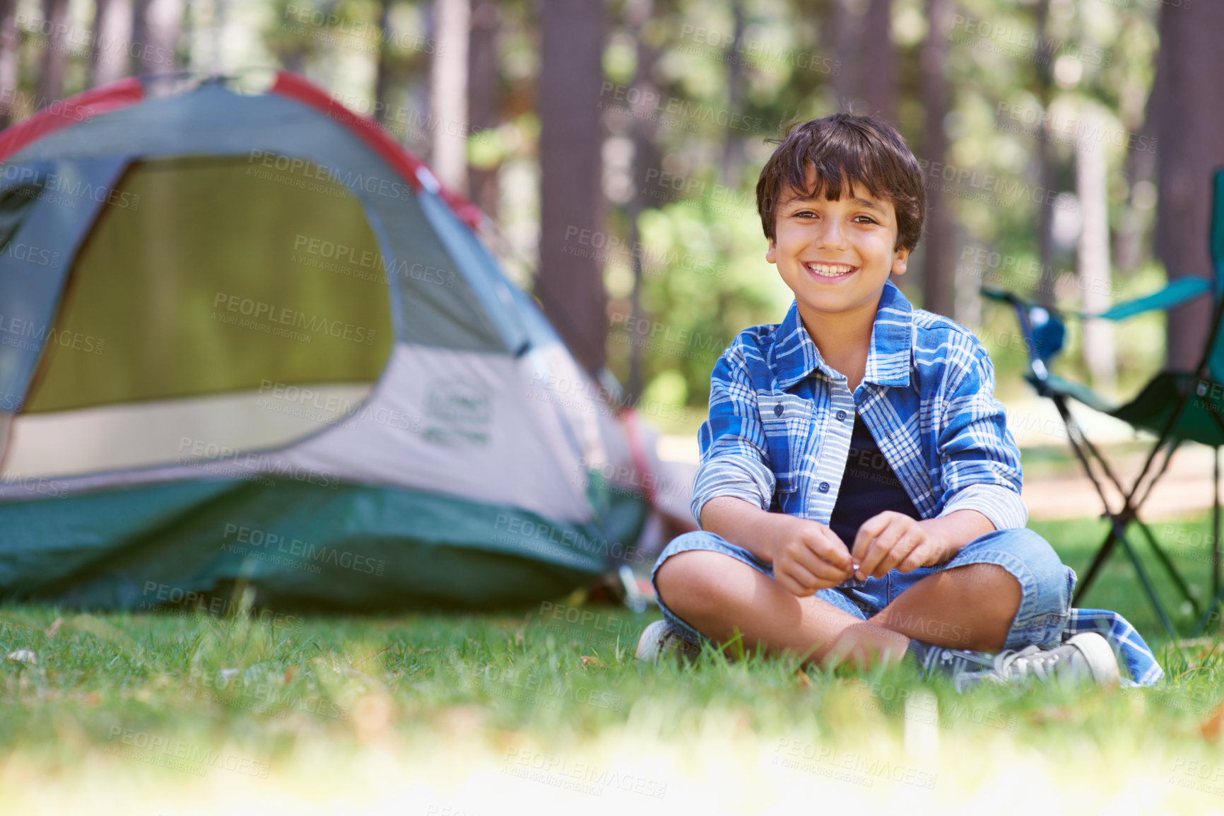 Buy stock photo Portrait of a young boy sitting in the forest in front of a tent