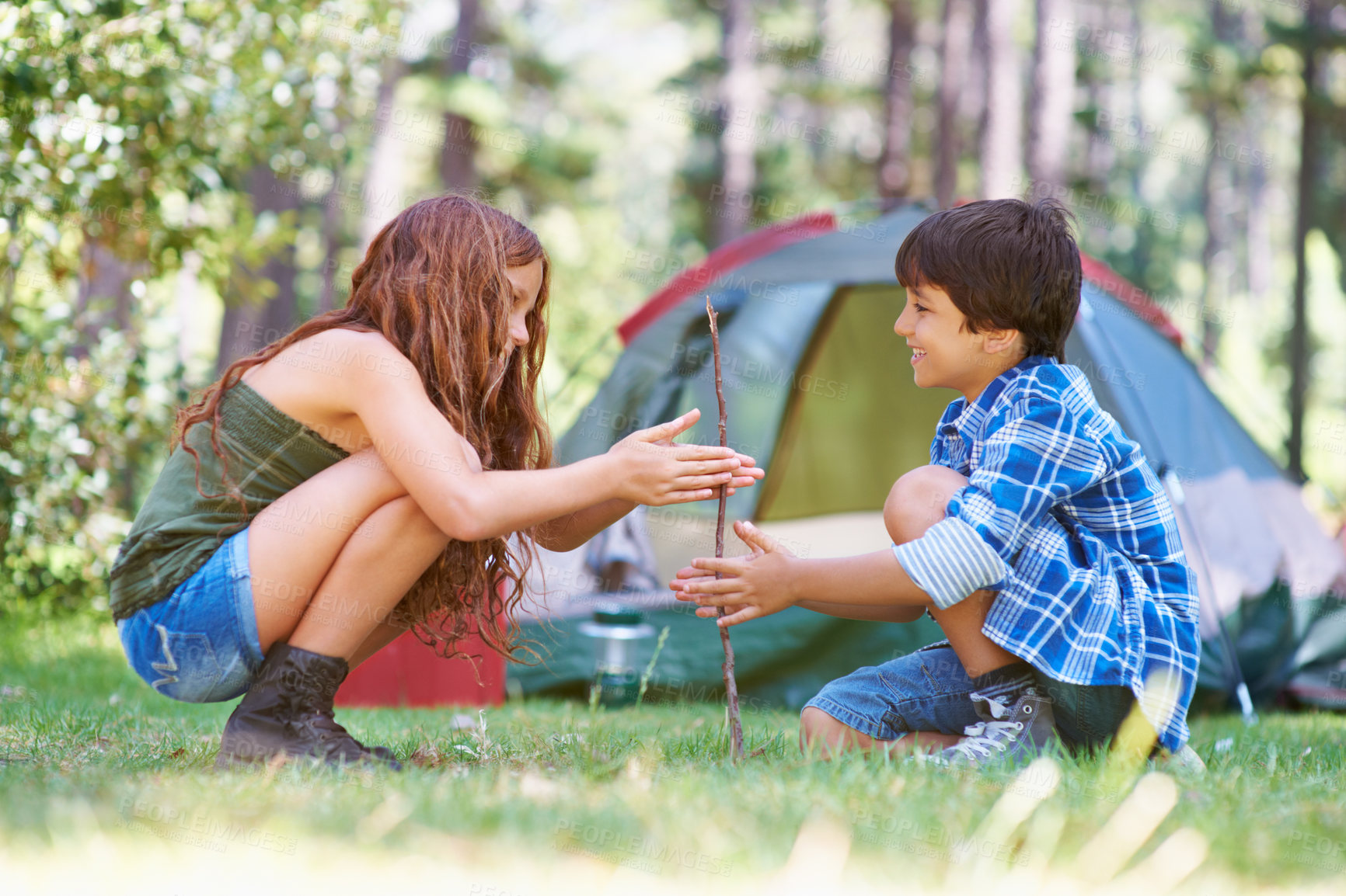 Buy stock photo A young brother and sister starting a campfire