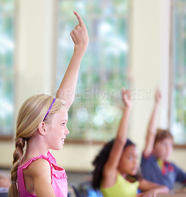 Buy stock photo Education, children and classroom or raise hands on school desk or excited kids for test and learning on bokeh. Knowledge, study and table for asking or exam answer or growth and child development