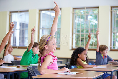 Buy stock photo Children, classroom and raise hands on school desk or excited kids learning for test and future information. Education, knowledge and table for asking or exam answer or growth and child development