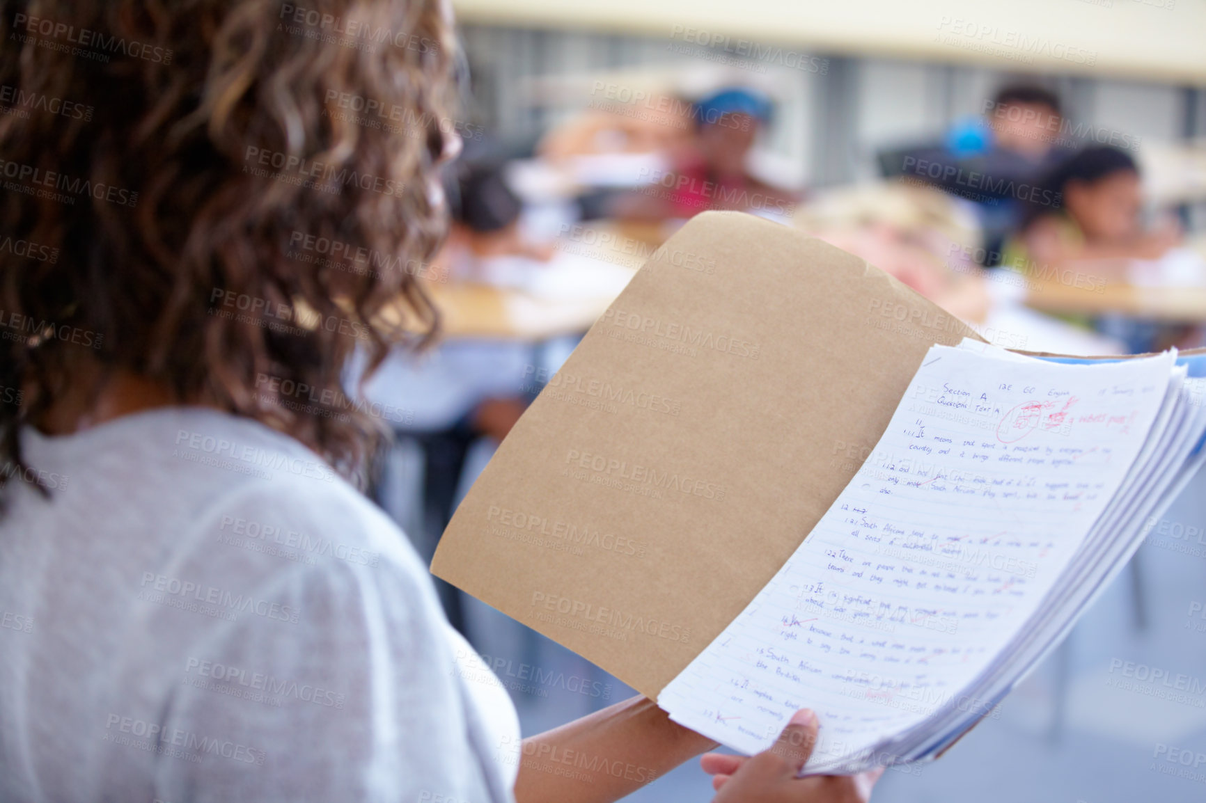 Buy stock photo An over the shoulder view of a teacher reading out student marks