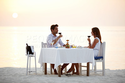 Buy stock photo Love, ocean sunset and couple drinking wine at table at romantic valentines day date at beach in Bali. Romance, food and celebrate on vacation for man and woman in valentine relationship in Indonesia