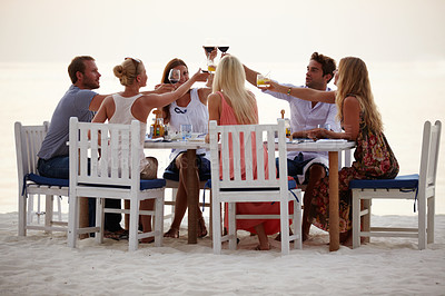 Buy stock photo Beach, party and friends cheers at table on sand with food, wine and people on island holiday in Bali. Summer, celebrate friendship and happy outdoor dinner toast with drink on vacation in Indonesia.