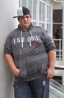 Buy stock photo Plus size, young guy and portrait outdoor with hipster and urban style feeling serious. Student, gen z fashion and cool clothing of a heavy male person with youth and confidence with hands in pocket