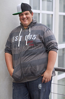 Buy stock photo Plus size, young man and portrait outdoor with hipster and urban style with a smile. Happy, gen z fashion and cool clothing of a heavy male person with youth and confidence with hands in pockets