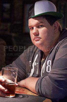 Buy stock photo Man portrait, pub beer and plus size person waiting for a alcohol and drink looking serious. Male person, restaurant and glass pint sitting at a counter at a club with gen z, cool and urban fashion 