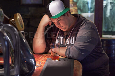 Buy stock photo A young man looking lonely at the bar