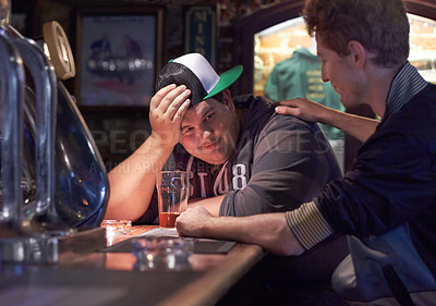 Buy stock photo A young man being consoled by a friend at the bar