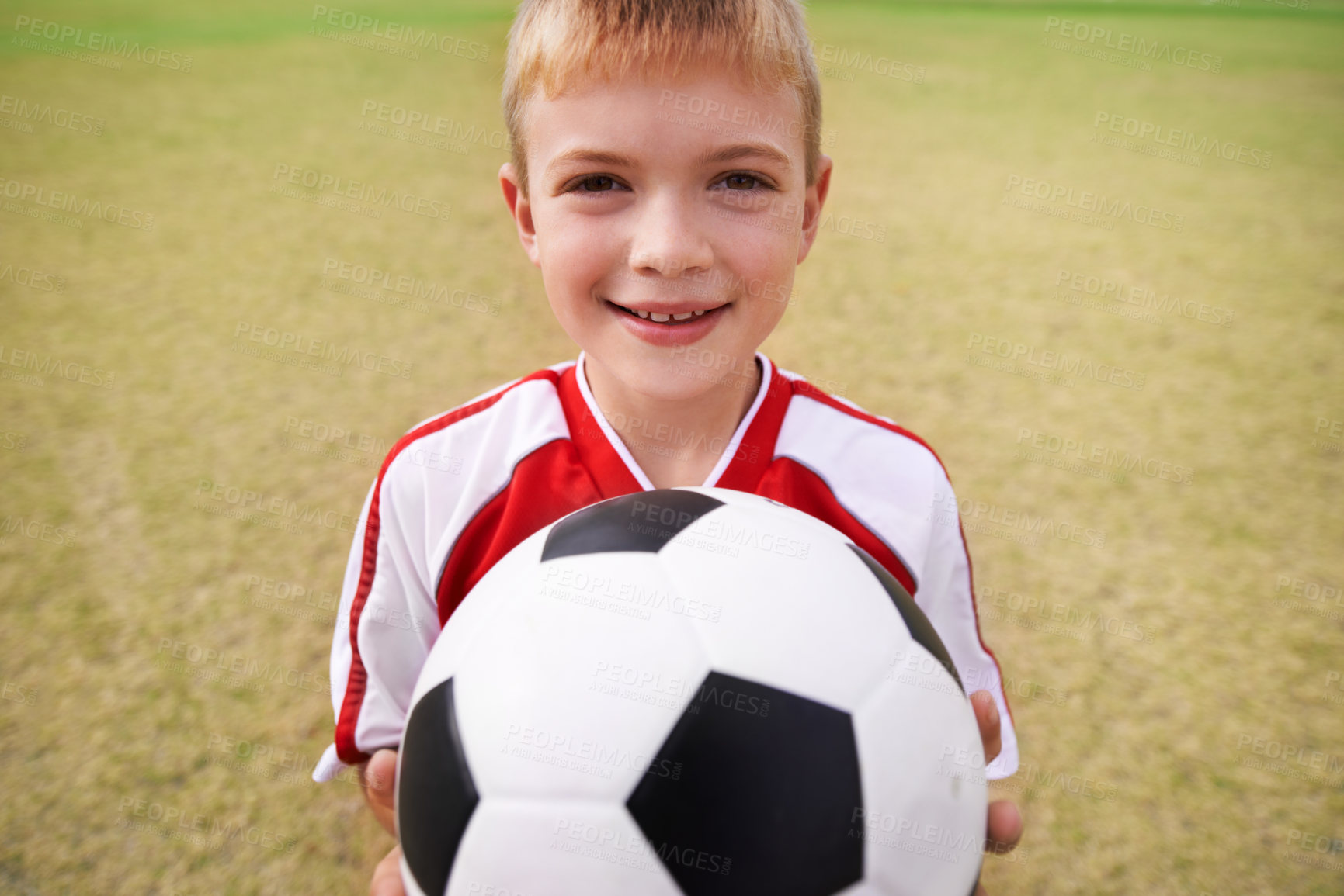 Buy stock photo Boy, soccer player and ball with portrait, smile and ready for game, field and child. Outdoor, playful and sport for childhood, happy and athlete for match, alone and outside on football pitch