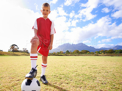 Buy stock photo Happy child, soccer ball and sports on green grass for training or practice with clouds and blue sky. Portrait of young football player smile ready for kick off game, match or outdoor field in nature