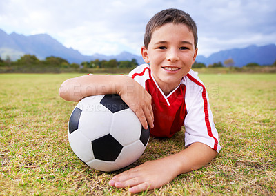 Buy stock photo Boy, soccer player and ball with portrait, happy and ready for game, field and child. Outdoor, playful and sport for childhood, uniform and athlete for match, alone and outside on football pitch