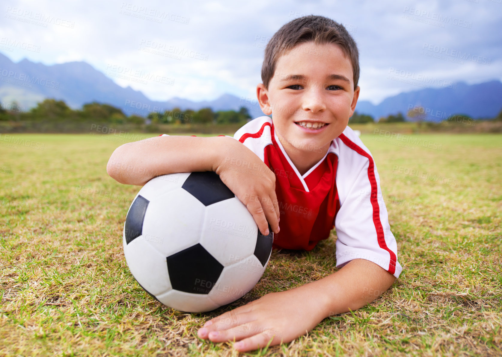 Buy stock photo Boy, soccer player and ball with portrait, happy and ready for game, field and child. Outdoor, playful and sport for childhood, uniform and athlete for match, alone and outside on football pitch