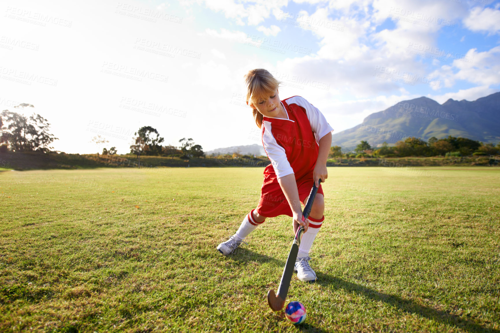 Buy stock photo Girl, green grass and playing hockey for sports, game or outdoor match in nature for practice. Female person, kid or playful child enjoying competition with ball on field for fitness or training