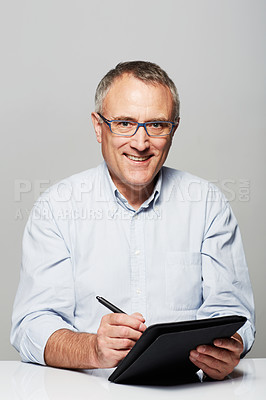 Buy stock photo Studio portrait of a mature man working on a digital tablet