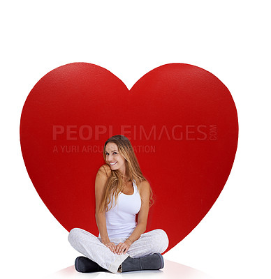 Buy stock photo Portrait, studio and woman sitting by heart isolated on a white background. Beauty, love and smile of happy female model near big symbol for romance, affection or romantic emoji, care or empathy.