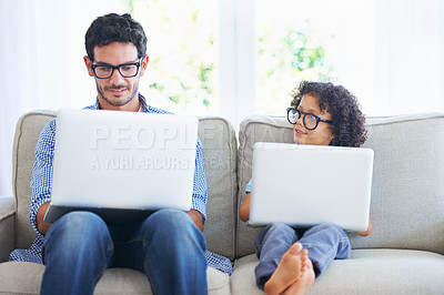 Buy stock photo Shot of a father and sone using laptops on the living room sofa