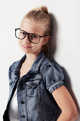 Buy stock photo Child, portrait and smiling with glasses in studio, cool and confidence by white background. Female person, girl and casual clothing or style by backdrop, kid and denim jacket pride for eyesight test